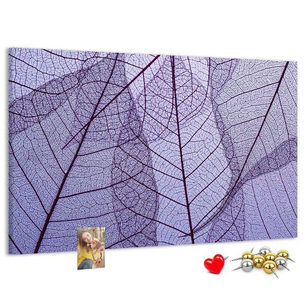 Tablero de corcho decorado con un delicado estampado de hojas sobre un fondo morado