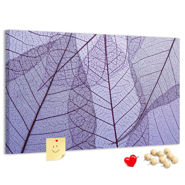 Tablero de corcho decorado con un delicado estampado de hojas sobre un fondo morado