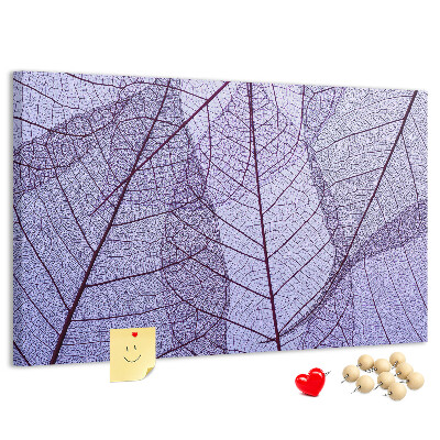 Tablero de corcho decorado con un delicado estampado de hojas sobre un fondo morado