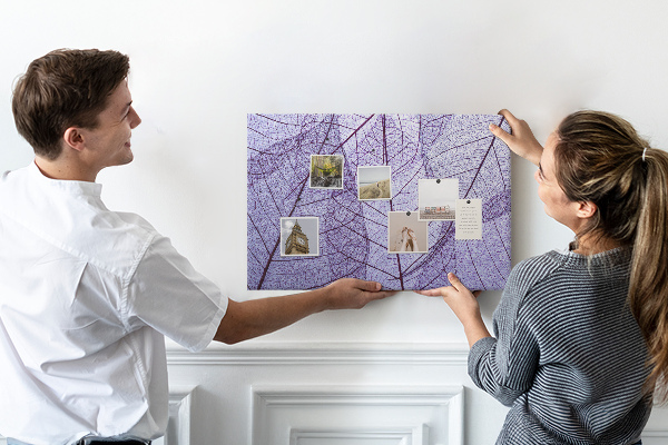 Tablero de corcho decorado con un delicado estampado de hojas sobre un fondo morado
