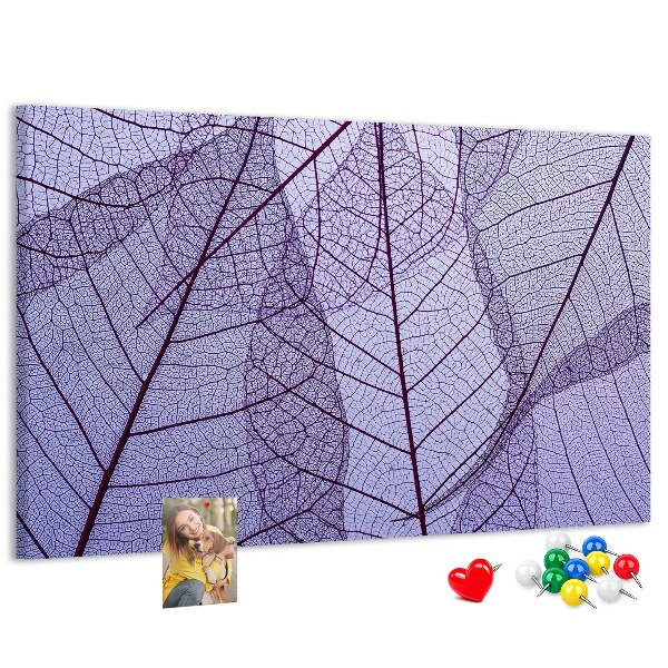 Tablero de corcho decorado con un delicado estampado de hojas sobre un fondo morado