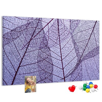 Tablero de corcho decorado con un delicado estampado de hojas sobre un fondo morado