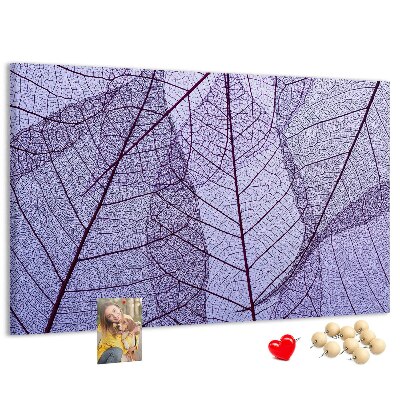 Tablero de corcho decorado con un delicado estampado de hojas sobre un fondo morado