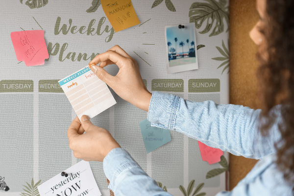 Pizarra de corcho con diseño de agenda semanal y estampado de plantas