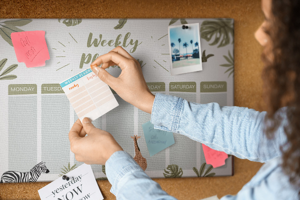 Pizarra de corcho con diseño de agenda semanal y estampado de plantas