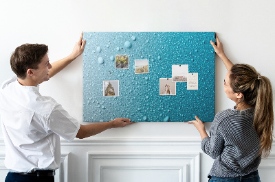 Tablero de corcho decorado gotas de agua sobre un fondo azul