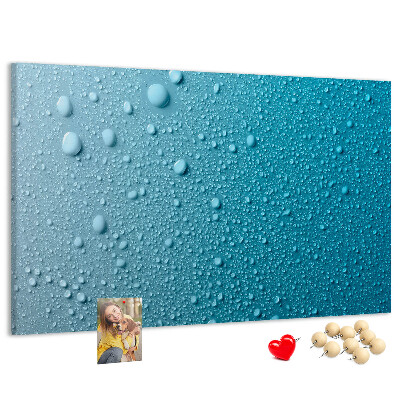 Tablero de corcho decorado gotas de agua sobre un fondo azul