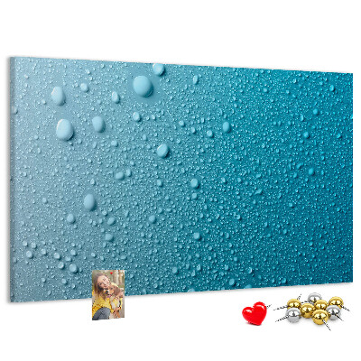 Tablero de corcho decorado gotas de agua sobre un fondo azul