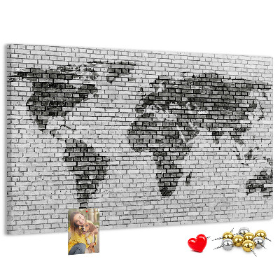 Pizarra de corcho mapamundi sobre fondo de pared de ladrillos