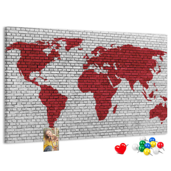 Tablero de corcho decorativo con diseño de contorno rojo del mundo sobre pared de ladrillos
