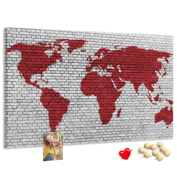 Tablero de corcho decorativo con diseño de contorno rojo del mundo sobre pared de ladrillos