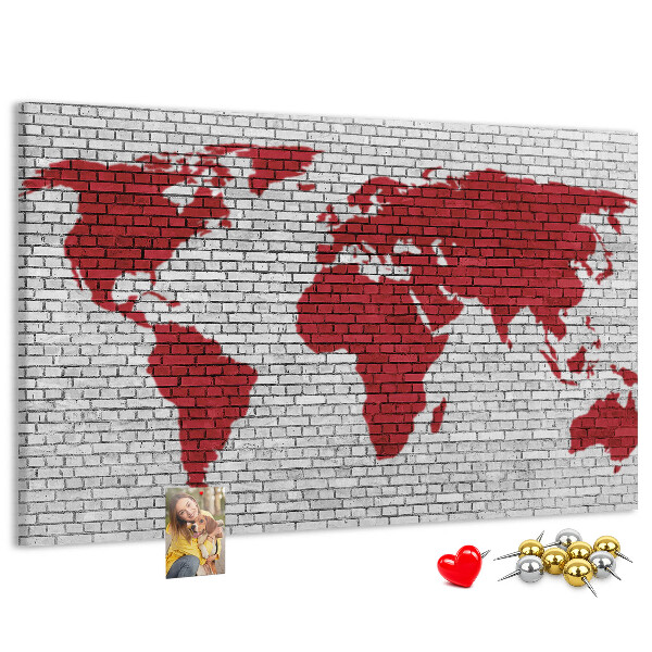 Tablero de corcho decorativo con diseño de contorno rojo del mundo sobre pared de ladrillos