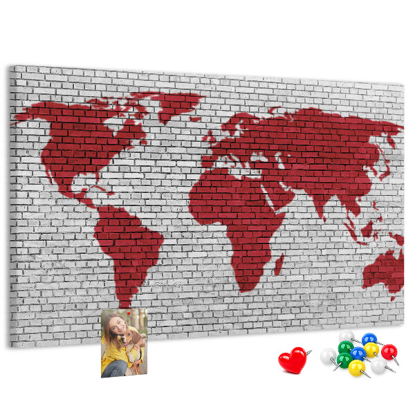 Tablero de corcho decorativo con diseño de contorno rojo del mundo sobre pared de ladrillos