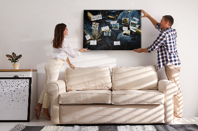 Tablero de corcho decorativo hojas doradas sobre un fondo azul oscuro