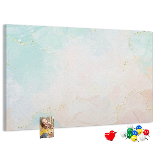 Tablero de corcho decorado con delicados lunares en tonos pastel y detalles dorados