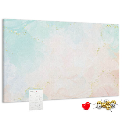 Tablero de corcho decorado con delicados lunares en tonos pastel y detalles dorados