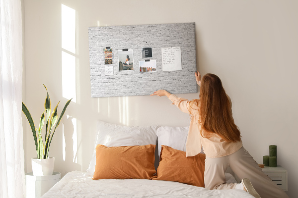 Tablero de anuncios con diseño de pared de ladrillo blanco y chinchetas de colores
