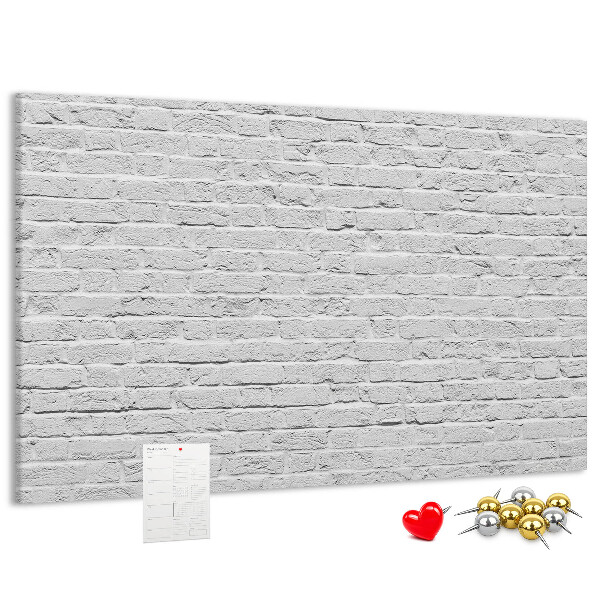 Tablero de anuncios con diseño de pared de ladrillo blanco y chinchetas de colores