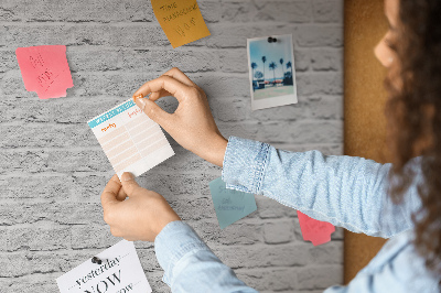Tablero de anuncios con diseño de pared de ladrillo blanco y chinchetas de colores