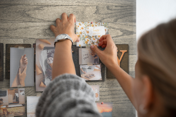 Tablero de corcho decorado con diseño de cartas familiares sobre fondo de madera