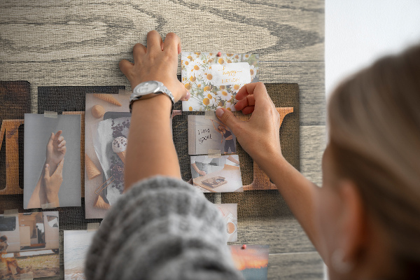 Tablero de corcho decorado con diseño de cartas familiares sobre fondo de madera