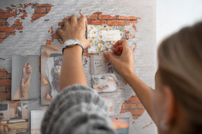 Tablero de corcho decorado Un mapamundi contra una pared de ladrillos