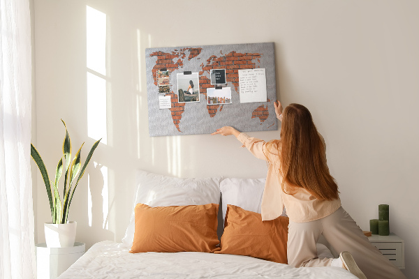 Tablero de corcho decorado Un mapamundi contra una pared de ladrillos