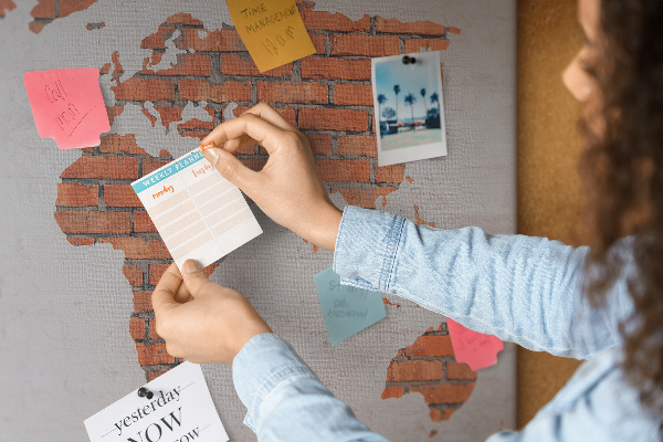 Tablero de corcho decorado Un mapamundi contra una pared de ladrillos