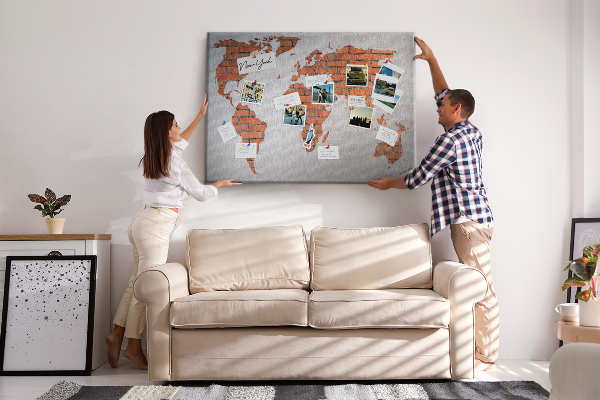 Tablero de corcho decorado Un mapamundi contra una pared de ladrillos