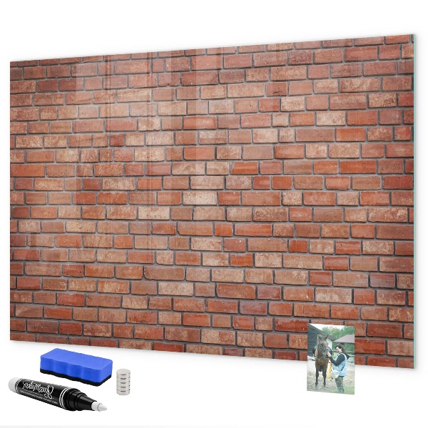 Pizarra borrable de cristal con imanes Un tablero de notas en una pared de ladrillos.
