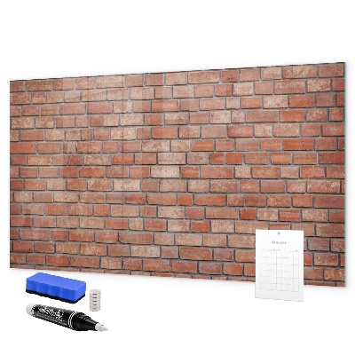 Pizarra borrable de cristal con imanes Un tablero de notas en una pared de ladrillos.